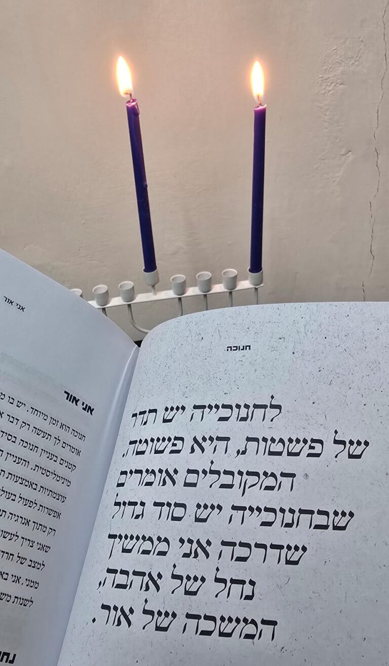 ספר חנוכה ליד נרות חנוכה
